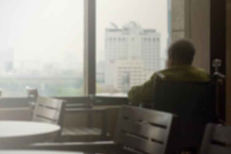 older nursing home resident in wheelchair looking out window