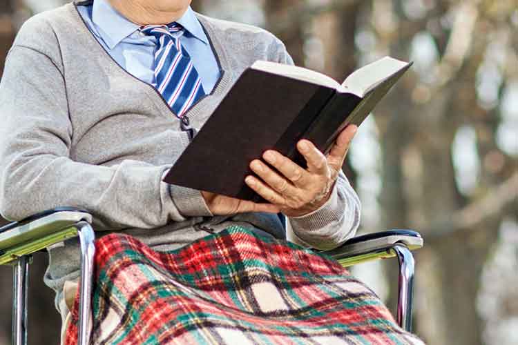 older person reading a book | Image