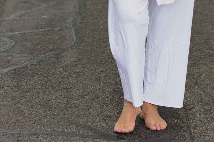 Elderly person with no shoes on the road | Image