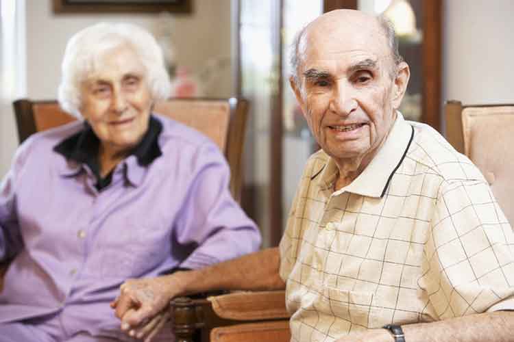 Older couple sitting and holding hands | Image