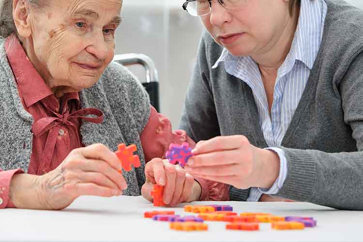 Elderly woman playing with puzzles | Image