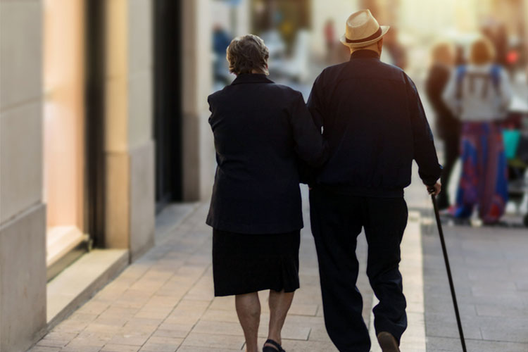 Two senior people walk arm in arm dressed nicely