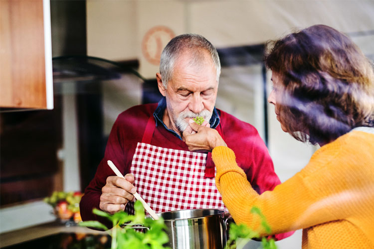 old man with oral sense loss is cooking in the kitchen with lady