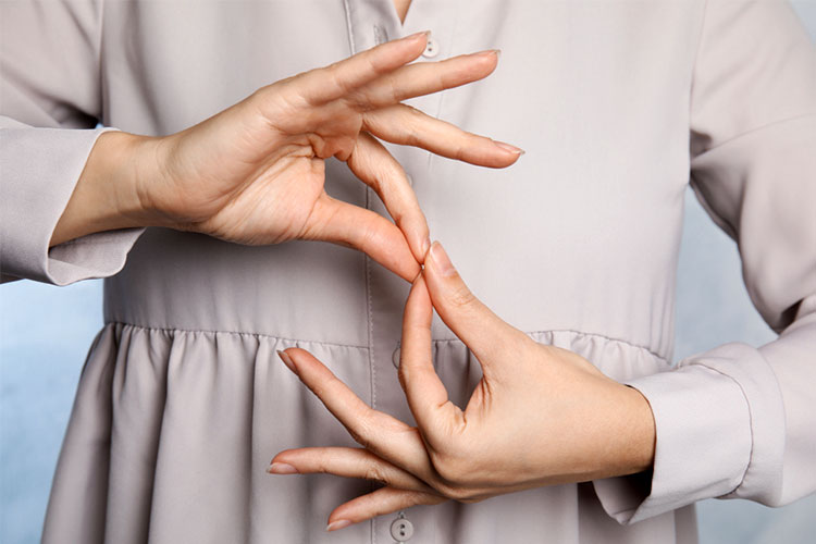 person is doing sign language for someone who has deafblindness