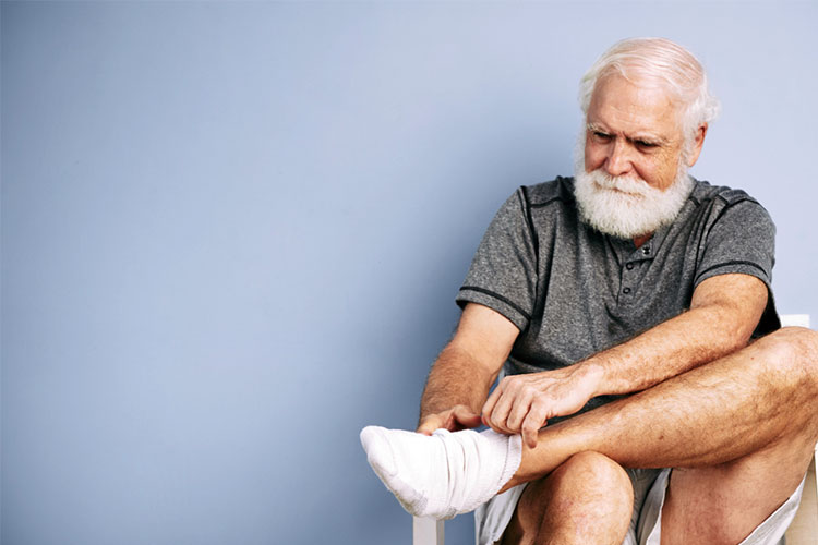 older male putting socks on