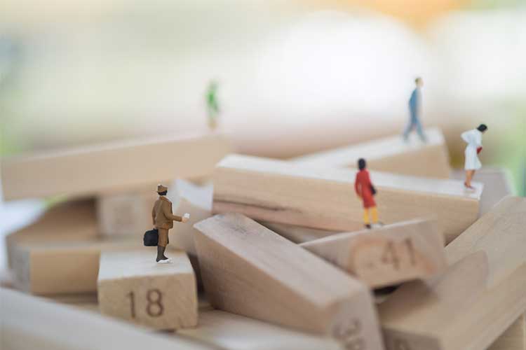 Human figurines on jenga blocks | Image