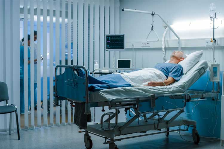 Elderly male patient lying in hospital bed