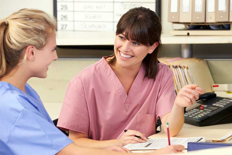 Two nurses talking during a meeting | Image