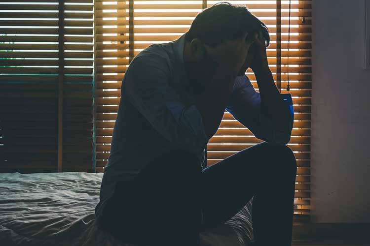 Man in despair sitting on bed | Image