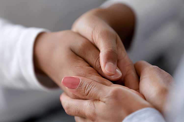 One person holding another persons hands | Image