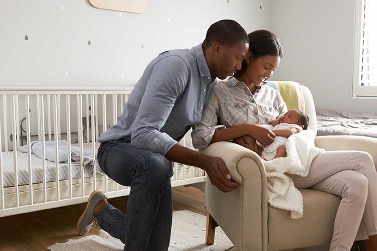 Young couple comforting baby in a nursery