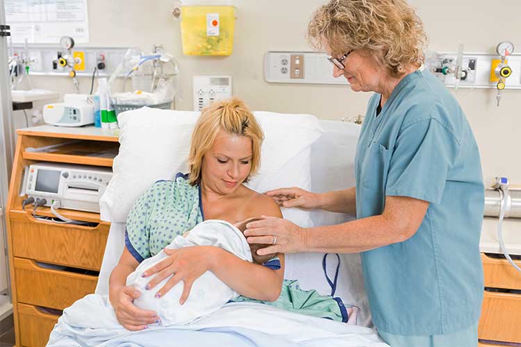 Mother breastfeeding her baby in a hospital bed