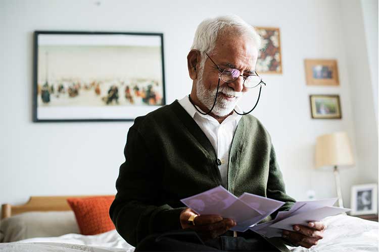 Elderly male looking at photos | Image