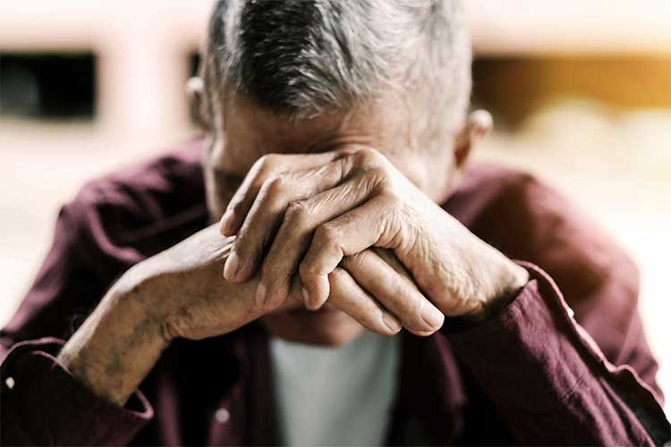 Elderly man with his head in his hands | Image