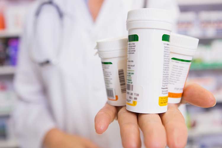 Pharmacists holding prescription medication | Image