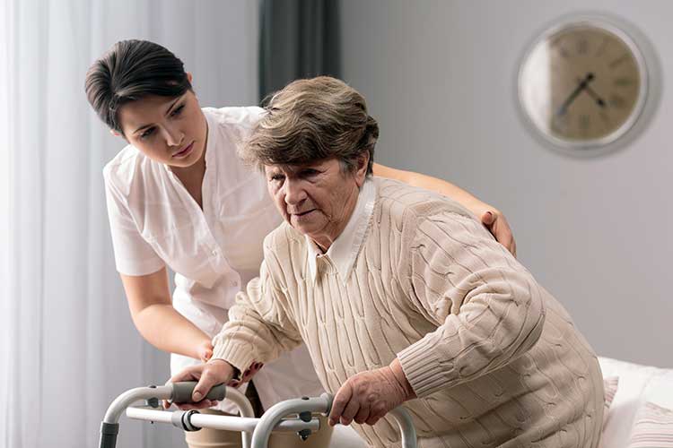 nurse helping older woman to stand up