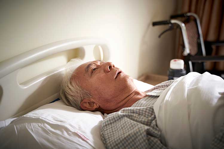 tired older man lying in bed