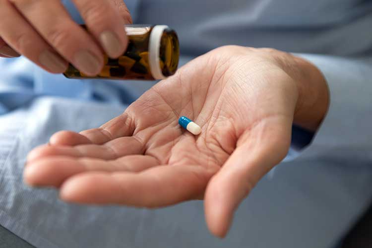 aged care resident holding antibiotic capsule