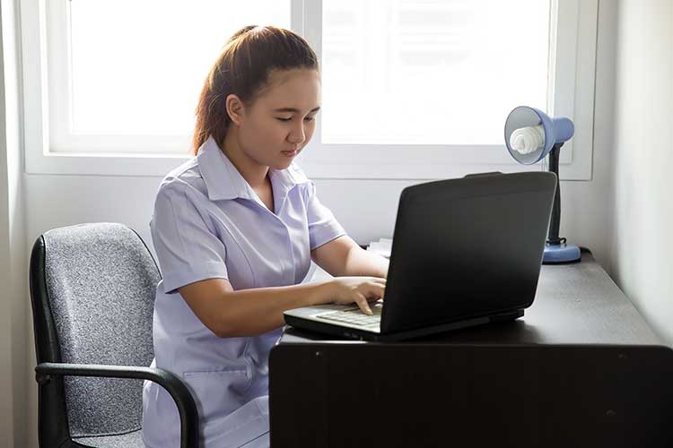 nurse researching on laptop