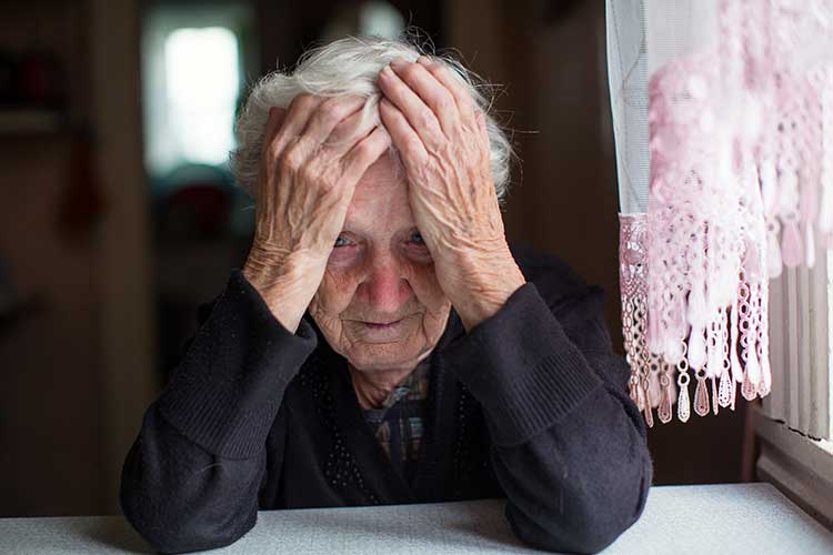 older woman sitting sadly