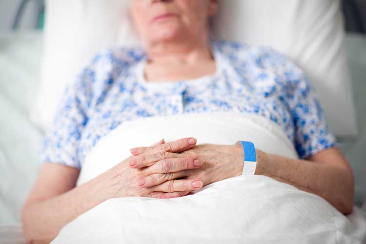 older woman lying in hospital bed