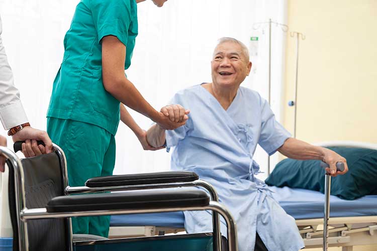 nurse helping older man get out of hospital bed