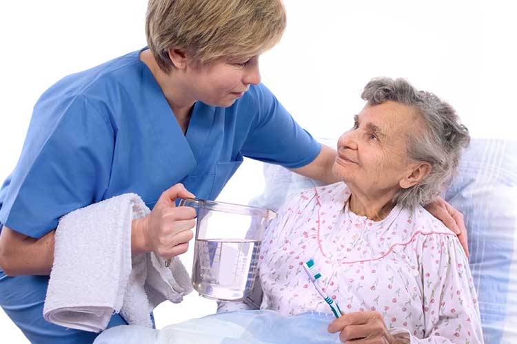 nurse helping older adult with oral hygiene