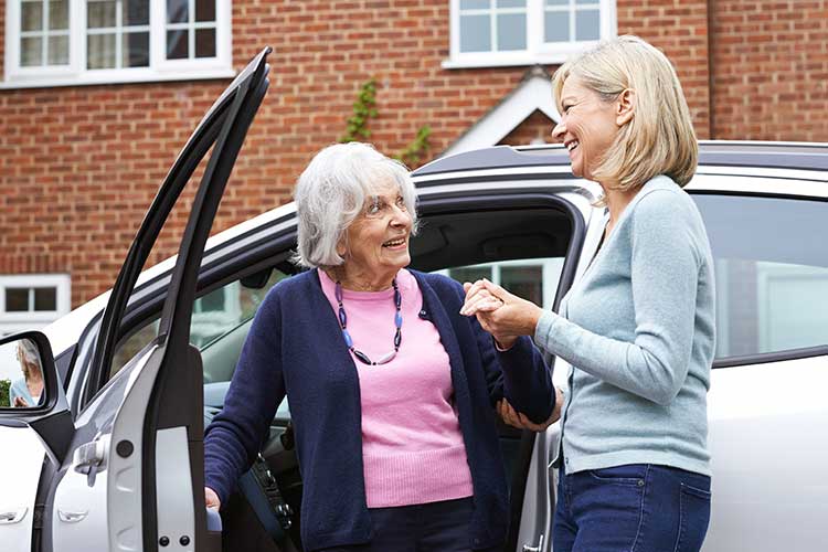 carer helping client get out of car