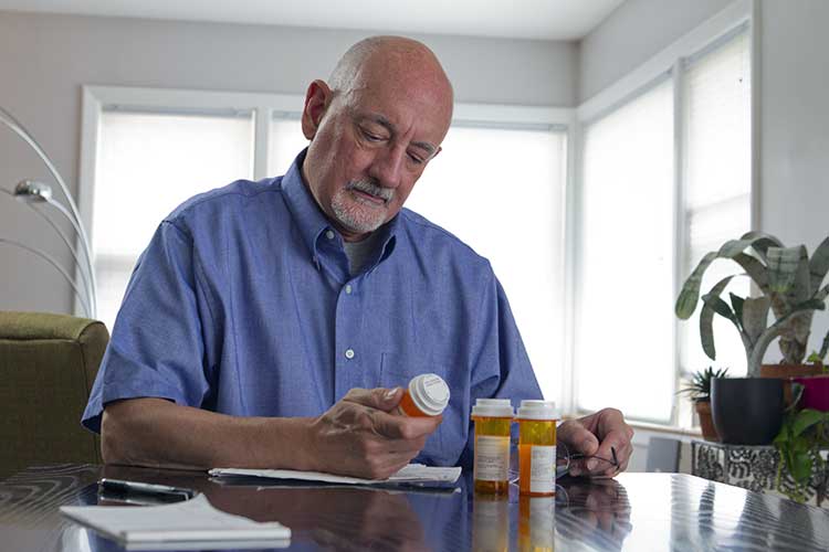 man checking medicine label for side effects